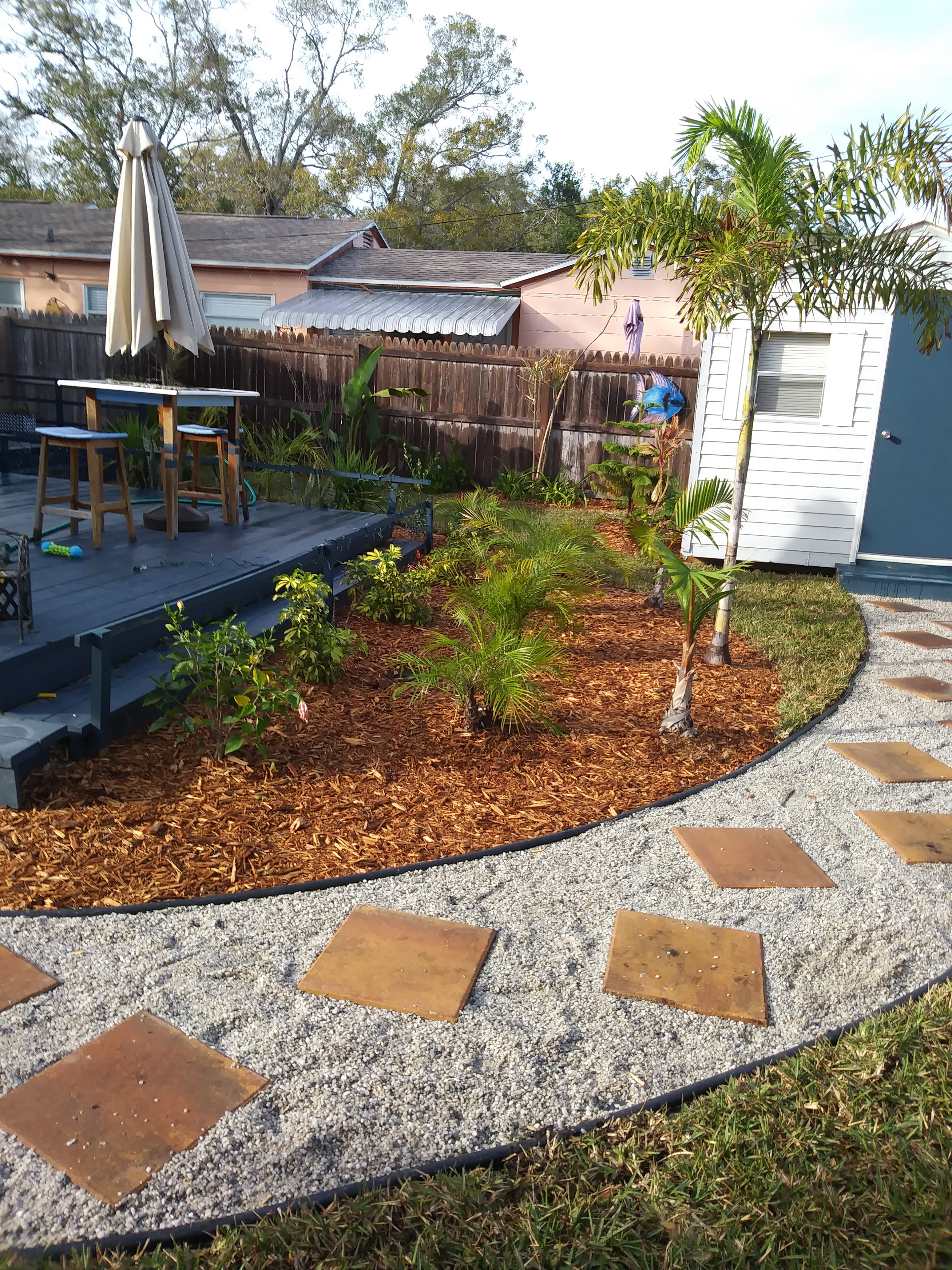 A Cozy Backyard Featuring a Patio Area Surrounded by a Wooden Fence.